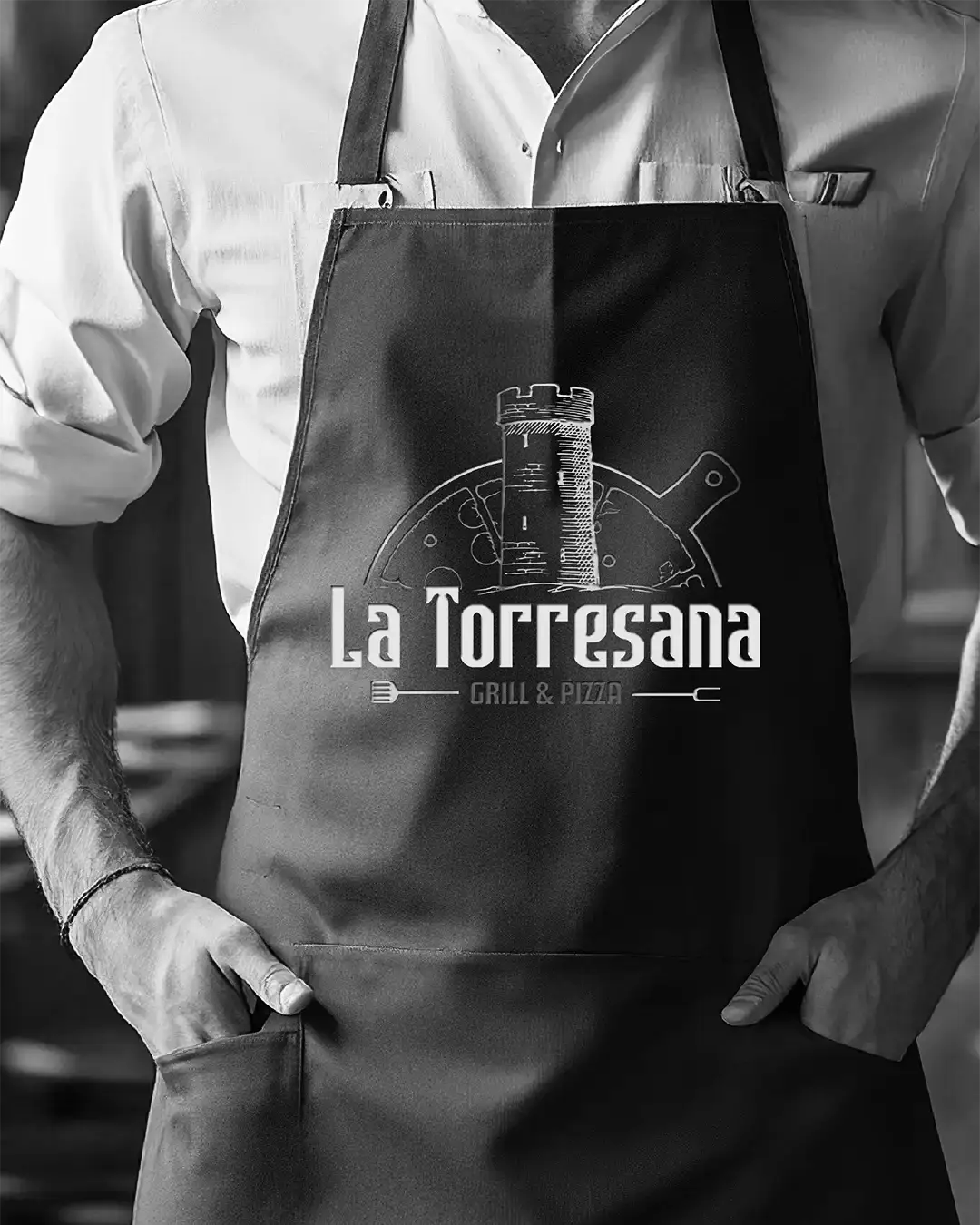 Delantal de cocina con el logotipo La Torresana Grill & Pizza aplicado en contexto real.