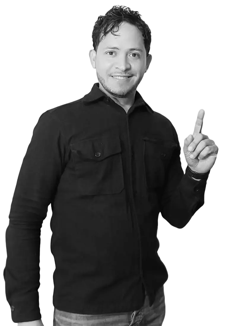 Camilo Guzmán, diseñador web y gráfico, sonriendo y señalando hacia un costado en una fotografía profesional.